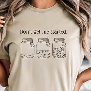Don't Get Me Started text above sourdough starter jars on natural Bella Canvas Tshirt
