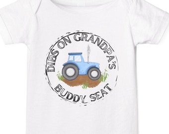 May include: White baby onesie with a blue tractor and the text "Dibs on Grandpa's Buddy Seat" in a black circle.