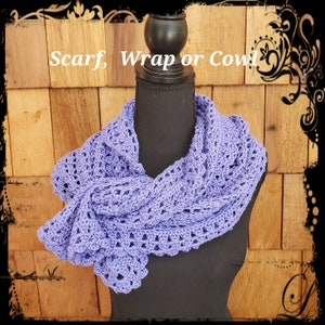 May include: A lavender crocheted scarf, wrap or cowl. The scarf is draped over a black mannequin against a wood background.