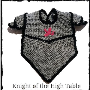 Op de afbeelding: Gehaakte grijze en zwarte baby slabbetje in de vorm van een ridderpantser, met een roze embleem. De slab heeft zwarte randen en de tekst "Knight of the High Table" onderaan.