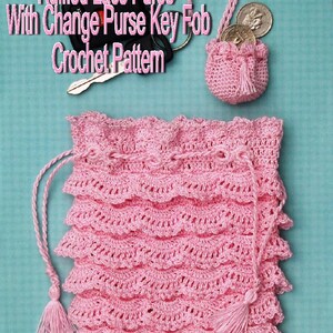 May include: A pink crocheted drawstring bag with a ruffled lace design. The bag has a tassel on the drawstring. The image also shows a smaller pink crocheted bag with a tassel, which is attached to a key chain with a key and coins.
