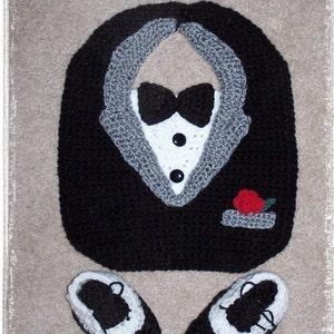 May include: A crocheted baby outfit in the shape of a tuxedo. The outfit includes a bib, bow tie, and two shoes. The bib is black with a white tuxedo shirt and gray lapels. The bow tie is black. The shoes are black with white trim. The text "Stepping Out With My Baby" is at the top of the image. The text "Designs by: Sharon Santorum" is at the bottom of the image.