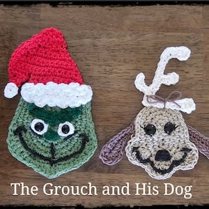 May include: A green crocheted Grinch wearing a red and white Santa hat, next to a brown crocheted dog with white antlers. The text "The Grouch and His Dog" is below the crocheted figures.