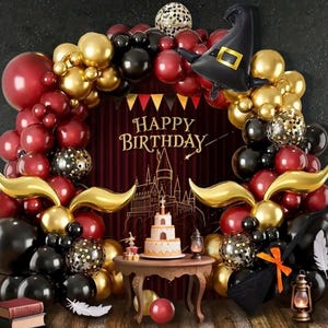Può includere: Una scena di festa di compleanno con un arco di palloncini rossi, dorati e neri. Una torta, un tavolo e decorazioni sono disposti su uno sfondo con il testo "HAPPY BIRTHDAY" e un'illustrazione di un castello. È presente anche un palloncino a forma di cappello da strega.