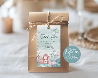 Può includere: Un'etichetta di ringraziamento blu chiaro con un'illustrazione di sirena e il testo "Thank You for celebrating with me! Jessica xx". L'etichetta è legata con uno spago a un sacchetto di carta marrone.