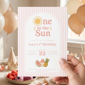 May include: A pink and white striped invitation card with the text "one in the Sun" and "Lucy's 1st Birthday". The card includes illustrations of a sun, watermelon, ice cream, and a pineapple. The card is held by a person.