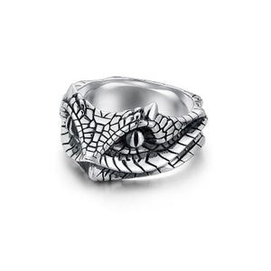 May include: A silver ring with a detailed snake head design. The ring has a textured pattern, with the snake's eye clearly visible. This ring is a bold statement piece, ideal for those who appreciate unique jewellery.