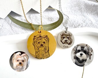 Puede incluir: Collares con colgantes de perro en oro y plata. Un colgante dorado presenta un retrato de perro, mientras que el colgante plateado tiene el nombre "Cora". También se incluye una pequeña foto de perro.