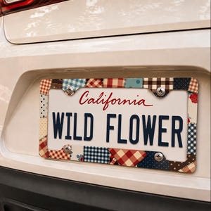 Puede incluir: Un marco rectangular para matrícula con un diseño de patchwork de varios patrones, incluyendo cuadros vichy rojos, azules y marrones, lunares y estampados florales. El marco está asegurado con cuatro tornillos plateados sobre una matrícula blanca de California.