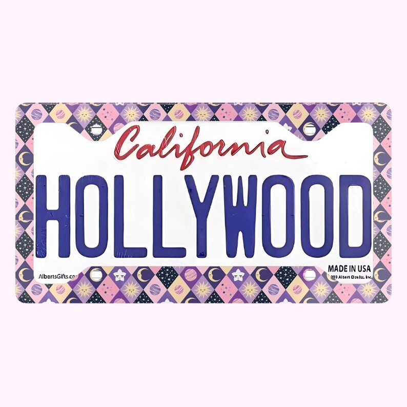 Może przedstawiać: Dekoracyjna tablica rejestracyjna z napisem "HOLLYWOOD" w kolorze niebieskim. Słowo "California" jest napisane czerwoną czcionką u g&oacute;ry. Obramowanie ma powtarzający się wz&oacute;r gwiazd, księżyc&oacute;w i romb&oacute;w w kolorze r&oacute;żowym, fioletowym i białym.