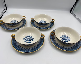 May include: Set of four blue and white porcelain soup bowls with gold trim and matching saucers. Each bowl features a stylized tree design.