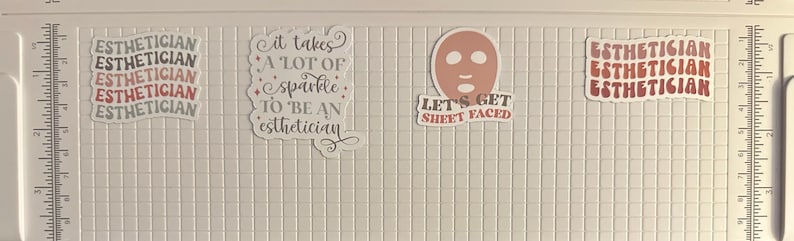 May include: Several stickers with text related to estheticians and skincare. One sticker reads "ESTHETICIAN" in a wavy font. Another says "It takes a lot of sparkle to be an esthetician." A third sticker shows a face mask and the words "LET'S GET SHEET FACED."