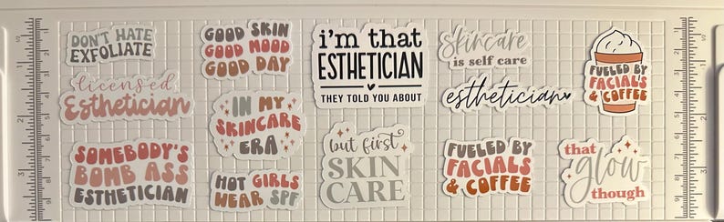 May include: A collection of stickers with skincare and esthetician-themed phrases. The stickers feature phrases like "Don't Hate Exfoliate," "Good Skin Good Mood Good Day," and "I'm That Esthetician." Colors include white, black, brown, and peach.