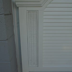 May include: White headboard with a woven wicker panel and horizontal slat design. The headboard has a curved top with molding and a rectangular woven panel in the center. The headboard is painted white.