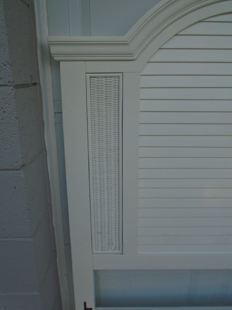 May include: White headboard with a woven wicker panel and horizontal slat design. The headboard has a curved top with molding and a rectangular woven panel in the center. The headboard is painted white.