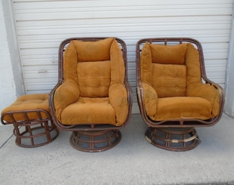May include: A set of three brown wicker chairs with orange cushions. The chairs have a swivel base and are perfect for a living room or patio.