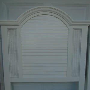 May include: White headboard with an arched top and horizontal slats. The headboard features woven wicker panels on either side of the slatted center section. A classic design for a bedroom.
