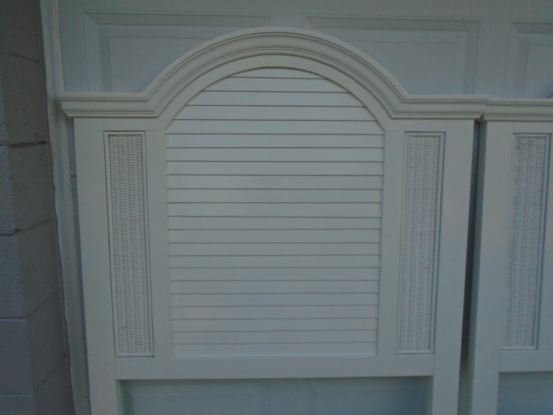 May include: White headboard with an arched top and horizontal slats. The headboard features woven wicker panels on either side of the slatted center section. A classic design for a bedroom.