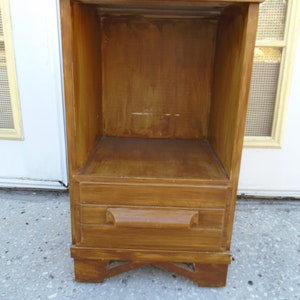 May include: A wooden end table with a single drawer and an open shelf. The table is stained a dark brown color and has a simple design.