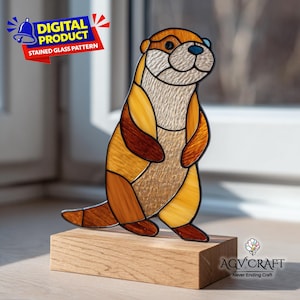 Pode incluir: Uma figura de lontra em vitral com segmentos de vidro âmbar, castanho e creme texturizado com linhas de chumbo pretas, em pé sobre uma base de madeira retangular. A imagem inclui uma faixa azul e vermelha com o rótulo DIGITAL PRODUCT STAINED GLASS PATTERN.