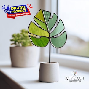 Puede incluir: Una hoja de Monstera de vidriera en tonos verdes, colocada en una pequeña maceta de hormigón. La imagen incluye el texto "PRODUCTO DIGITAL PATRÓN DE VIDRIERA" y "AGV CRAFT Never Ending Craft".