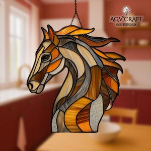 Peut inclure: T&ecirc;te de cheval en vitrail aux tons marron, orange et cr&egrave;me, suspendue &agrave; une cha&icirc;ne. L'&oelig;uvre pr&eacute;sente un motif de mosa&iuml;que d&eacute;taill&eacute; avec le texte "AGV Craft Never Ending Craft".