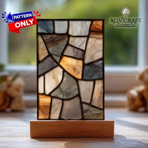 May include: A rectangular stained glass panel with a mosaic design of various stone colors, including gray, brown, and beige, set in a black frame. The panel is mounted on a rectangular wooden base. The text "PATTERN ONLY" is visible.