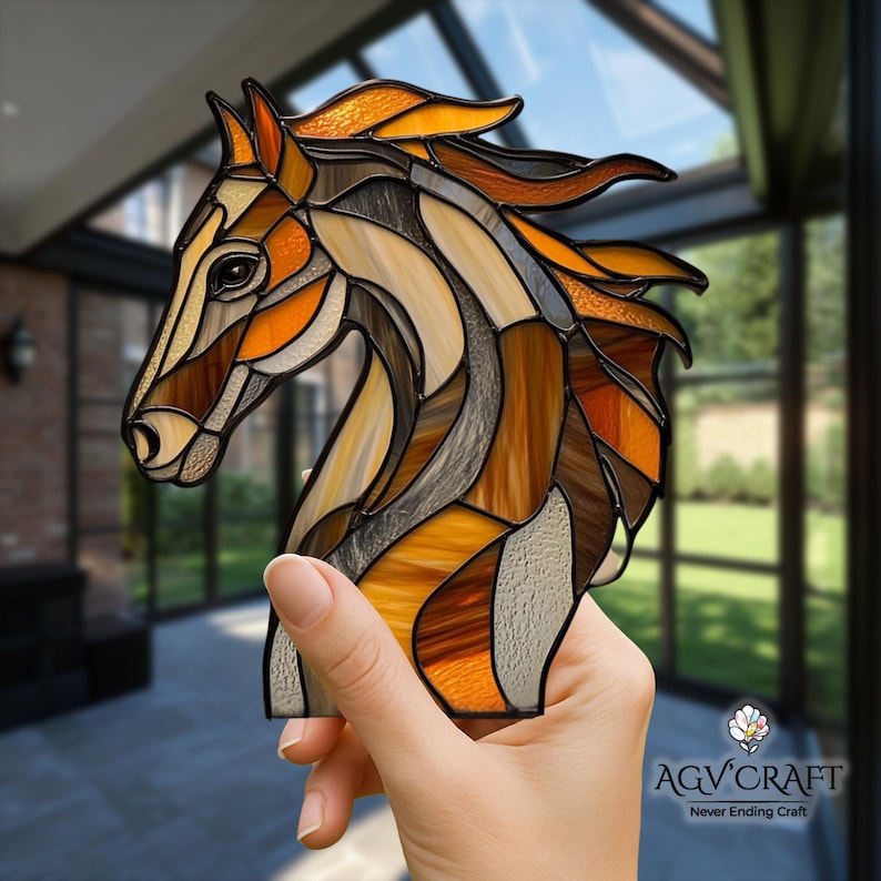 Peut inclure: Sculpture en vitrail repr&eacute;sentant une t&ecirc;te de cheval dans des tons de marron, orange et cr&egrave;me. L'&oelig;uvre pr&eacute;sente un motif en mosa&iuml;que avec un contour noir, mettant en valeur le profil du cheval. La sculpture est tenue devant un arri&egrave;re-plan flou.