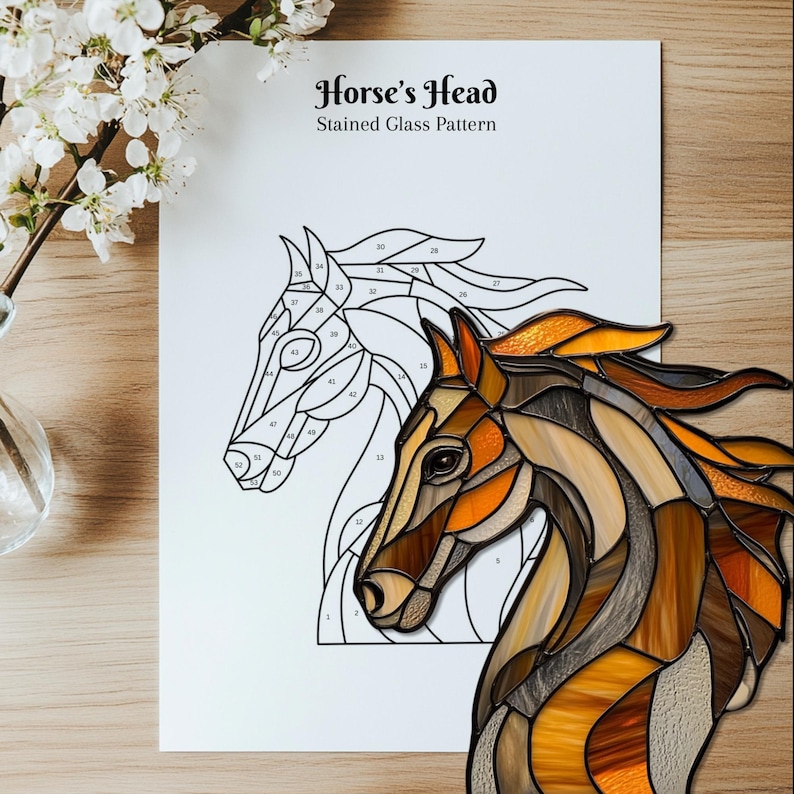 Peut inclure: Un patron de vitrail intitul&eacute; "Horse's Head" pr&eacute;sentant un contour d&eacute;taill&eacute; et un motif termin&eacute;. La t&ecirc;te de cheval finie est r&eacute;alis&eacute;e dans des tons de marron, d'orange et d'ambre. Le motif est sur papier blanc, avec un fond en bois.