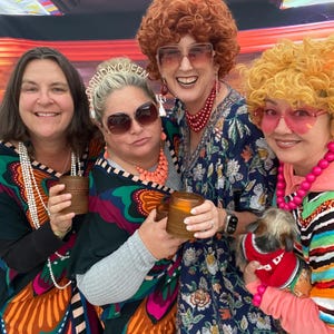 Four women dressed in wigs and caftans dressed as Mrs. Roper for a Threes Company Roper Romp Party