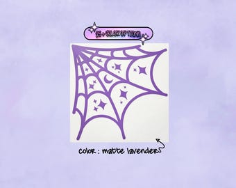 May include: A matte lavender vinyl decal featuring a spider web design with integrated star and crescent moon shapes. Above the web, a text box reads 25+ COLOR OPTIONS, and below, text indicates the color is matte lavender.