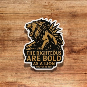 May include: A sticker featuring a roaring lion in gold and black. The text reads "THE RIGHTEOUS ARE BOLD AS A LION PROVERBS 28:1" in a bold, easy-to-read font. The sticker has a white border and is set against a wooden background.