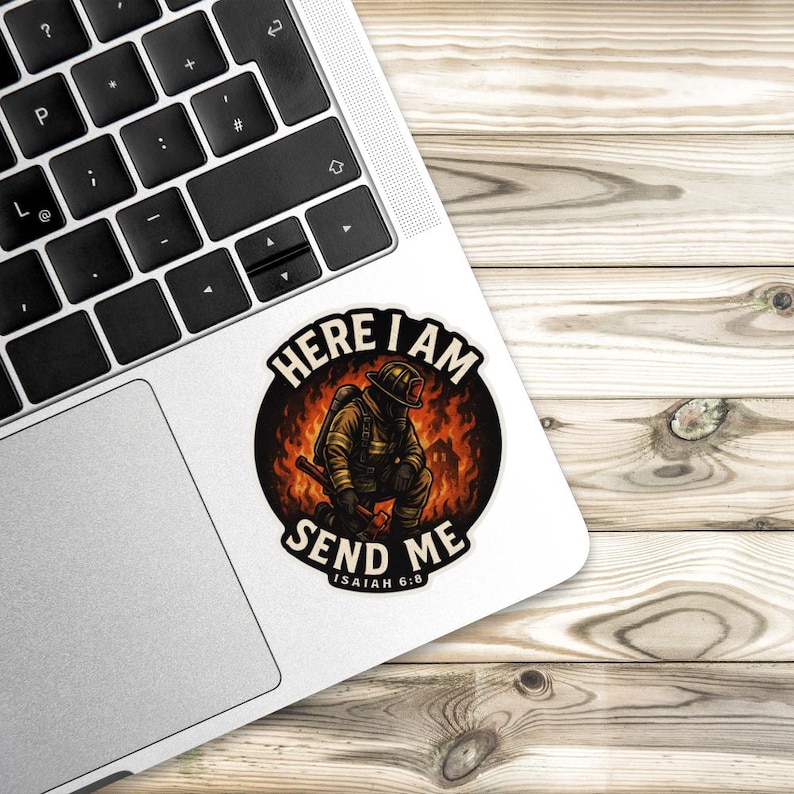 Die cut sticker of firefighter kneeling in front of flames holding axe with words “Here I Am Send Me” and “Isaiah 6:8” in bold lettering.