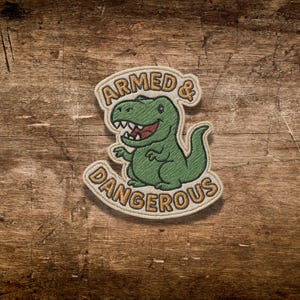 Funny T-Rex Die Cut Sticker – “Armed & Dangerous” Dinosaur Vinyl Decal for Water Bottles, Laptops, Journals, Gifts for Dino Lovers