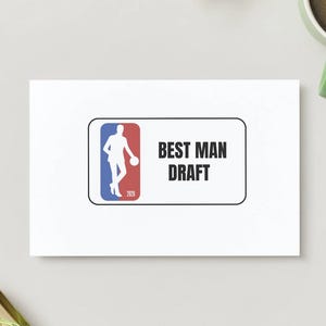 May include: A white card with the text "BEST MAN DRAFT" in black. The card features a logo with a basketball player in a red, white, and blue design. A green mug of coffee is in the upper right corner.