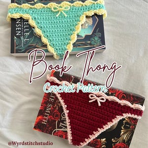 Könnte beinhalten: Zwei gehäkelte Buch-Tangas, einer türkis mit gelbem Besatz und einer Schleife, der andere bordeauxrot mit rosa Besatz und einer Schleife. Der Text "Book Thong Crochet Pattern" ist sichtbar. Die Buch-Tangas liegen auf Büchern.