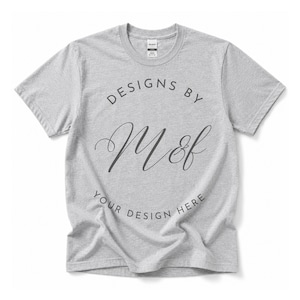 Könnte beinhalten: Ein graumeliertes Kurzarm-T-Shirt mit einem kreisförmigen Grafikdesign in Dunkelgrau. Der Text lautet "DESIGNS BY" oben, "M&f" in einer großen Schreibschrift in der Mitte und "YOUR DESIGN HERE" am unteren Rand des Kreises.