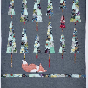 May include: A quilt with a gray background featuring a patchwork of colorful trees and a sleeping fox. The trees are made of various floral fabrics and the fox is orange with a white belly.