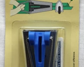 May include: A silver bias tape maker with a blue plastic guide. The tool is used to create bias tape for sewing projects. The package includes instructions for making bias tape.