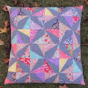 Könnte beinhalten: Ein grau-weißes Kissen mit geometrischem Muster. Das Kissen ist aus Stoff mit Blumenmuster und mit weichem, bequemem Material gefüllt.