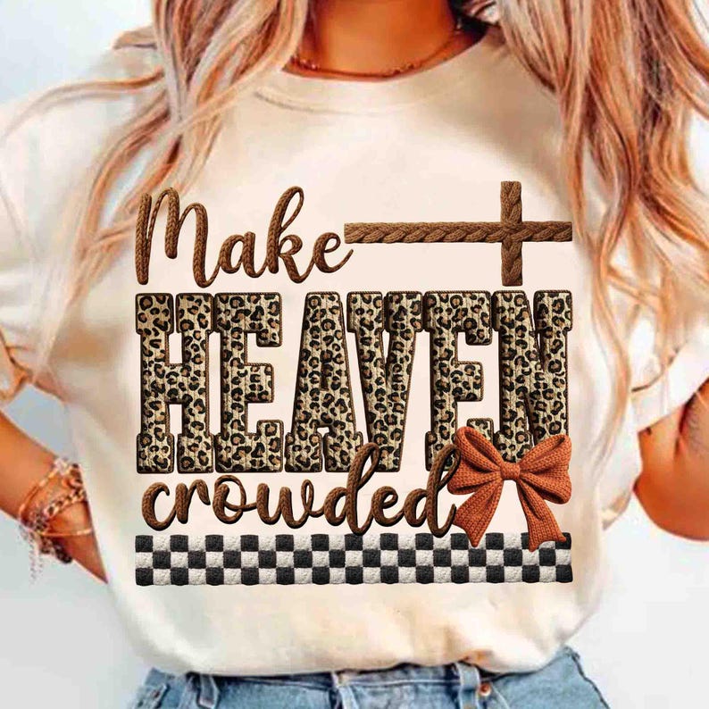 May include: Cream-colored t-shirt with the phrase "Make HEAVEN crowded" in brown and leopard print lettering. A brown cross and bow accent the design, with a black and white checkered border at the bottom. A casual, faith-based tee.