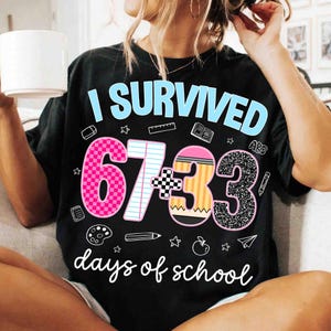 May include: Black t-shirt with the text "I Survived" in light blue. The shirt features the numbers "67+33" in pink, yellow, and black glitter, along with the words "days of school" in white.