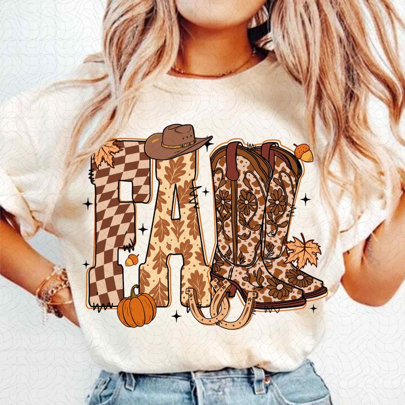 May include: Cream-coloured t-shirt with the word "FALL" in a fall-themed design. The letter "F" is a brown and white chequered pattern, "A" is a leaf pattern, and "L" features cowboy boots, a cowboy hat, and a pumpkin.