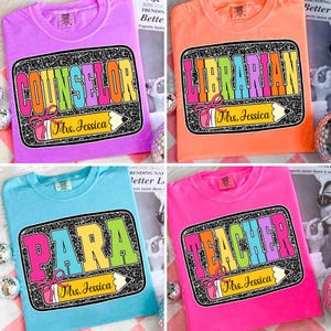May include: Four brightly coloured t-shirts: purple, orange, blue, and pink. Each shirt features a graphic with a profession title, a pencil, and the name "Mrs. Jessica". The titles are "Counselor", "Librarian", "Para", and "Teacher".