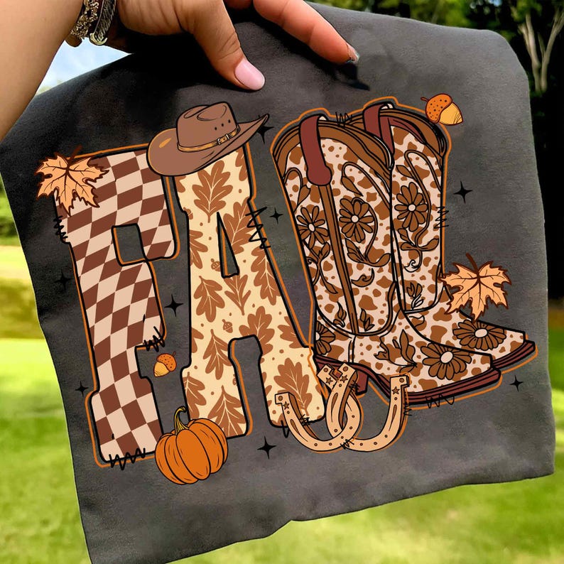 May include: Dark grey t-shirt with the word "FA" in brown and tan autumn designs. The "F" is checkered, and the "A" features oak leaves. A cowboy hat, boots, pumpkin, and horseshoe complete the autumn theme.