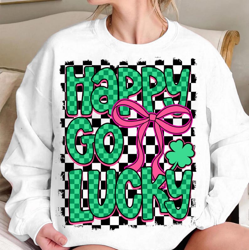 May include: White sweatshirt with a green and black checkered pattern and the text "Happy Go Lucky" in green letters with a pink bow and a green shamrock.