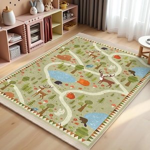 May include: A green and brown children's rug with a winding path and various woodland animals, including deer, foxes, and a bear. The rug has a white border with a brown and white geometric pattern.