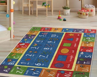 Puede incluir: Una alfombra de aprendizaje de letras y números colorida con fondo azul y acentos amarillos, rojos y verdes. La alfombra presenta letras, números y palabras para cada letra, como "cebra" para "Z" y "yate" para "Y".