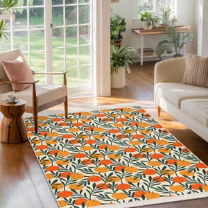 May include: A white area rug with a repeating pattern of orange and yellow fruit with green leaves on a white background.