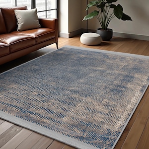 May include: A blue and beige area rug with a chevron pattern. The rug has a distressed look and a light grey border.